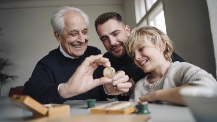 Happy watchmaker showing clockwork to young man and boy model released Symbolfoto property released PUBLICATIONxINxGERxSUIxAUTxHUNxONLY GUSF02178  