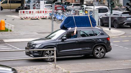 Symbolbild, wie ein Sofa wird auf dem Dach eines Auto transportiert wird.