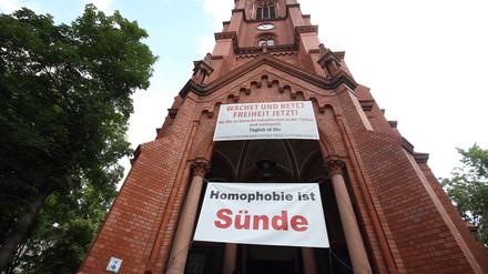 „Homophobie ist Sünde“-Banner an der Gethsemanekirche zum CSD 2021. Zum ersten Mal gab`s jetzt einen queeren Unigottesdienst.