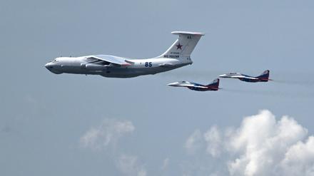 Ein russisches Militärtransportflugzeug vom Typ Il-80, bekannt als „Weltuntergangsflugzeug“, wird von zwei MiG-29-Kampfjets begleitet.