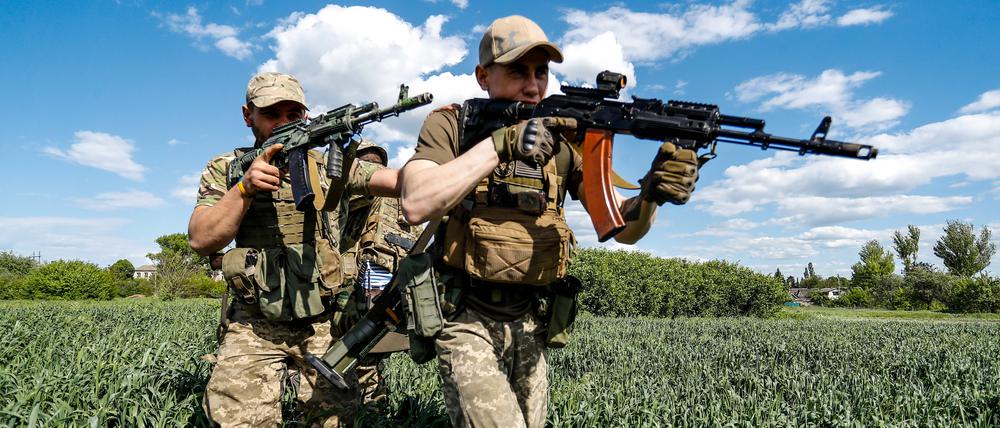Ukrainische Soldaten marschieren durch Gelände im Donbass.