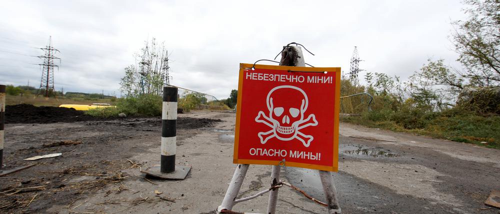 Ein Schild warnt vor Minen in ehemals besetztem Gebiet in der Region Charkiw.