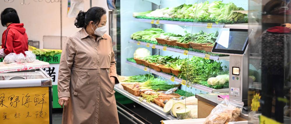 Eine chinesische Bürgerin mit Maske beim Einkaufen in der Stadt Guangzhou.