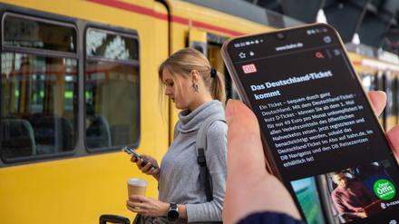 Nahaufnahme eines Smartphones vor einem Regionalzug