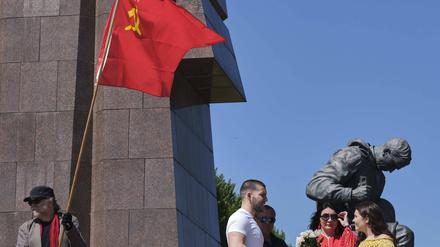 Ein Mann hält eine Sowjetfahne beim Gedenken an den Tag der Befreiung im Jahr 2020.