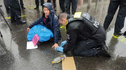 Bei strömendem Regen klebten einzelne Aktivist:innen auch am Mittag noch auf dem Asphalt.