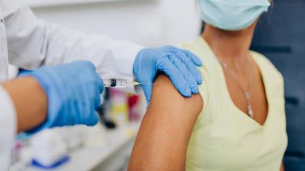 Eine Frau bekommt eine Impfung in den Oberarm (Symbolbild).