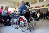 Ein Schüler im Rollstuhl sitzt gemeinsam mit nichtbehinderten Schülern in der Klasse.