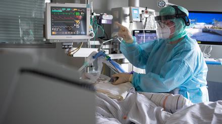 Eine Intensiv-Pflegerin versorgt einen schwer an Corona erkrankten Patienten auf der Intensivstation des Klinikums in Fulda.