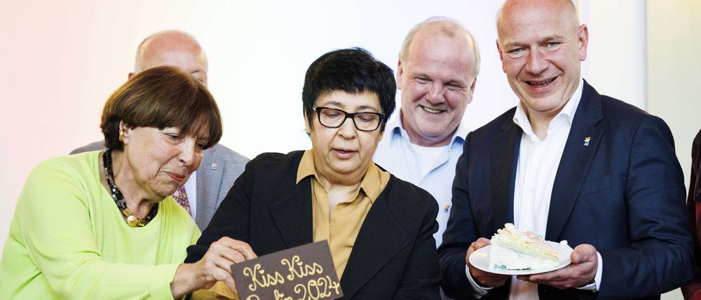 10.05.2024, Berlin: Kai Wegner (r.-l., CDU), Regierender Bürgermeister von Berlin, hält ein Stück «Kiss-Kiss-Regenbogenkuchen» neben Bastian Finke vom schwulen Anti-Gewalt-Projekt Maneo, Seyran Ates, Initiatorin und Mitbegründerin der Ibn-Rushd-Goethe-Moschee in Berlin, und Christa Arnet vom Fachbeirat vom schwulen Anti-Gewalt-Projekt Maneo, im Vorfeld zum Tag gegen Homo-, Bi-, Inter- und Transphobie im Roten Rathaus.