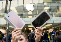 Frau mit neuen iPhones: Will Apple den Verkauf durch eine Leistungsbremse ankurbeln?