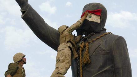 US-Soldaten bedecken eine Statue von Saddam Hussein mit einer irakischen Flagge (Archivbild vom April 2003). 