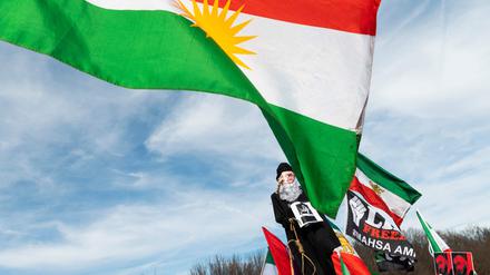 Aktivisten halten die iranische Flagge in die Höhe. 