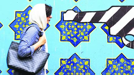 Eine iranische Frau in Teheran mit einem Wandgemälde. (Archivbild)