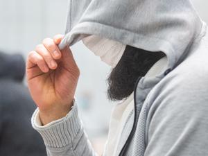 Abu Walaa, mutmaßlicher Anführer der Terrormiliz Islamischer Staat (IS) in Deutschland, steht im Oberlandesgericht Celle hinter einer Glasscheibe. 