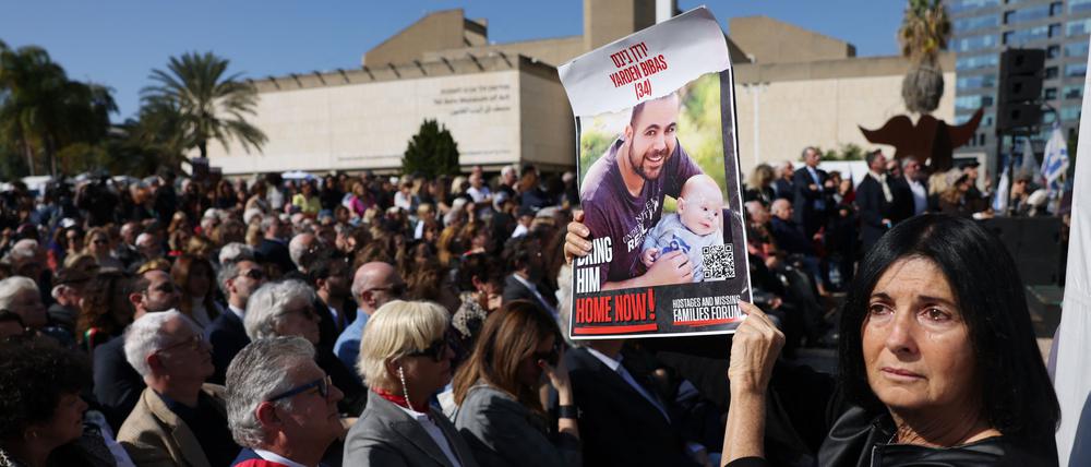 Eine Frau hält bei einem Protest ein Plakat von Jarden Bibas und seinem Sohn Kfir, der während der Entführung acht Monate alt war. 