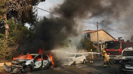 Nach einem Raketenangriff aus Gaza löschen Feuerwehrleute ein brennendes Auto  in Ashkelon im Süden Israels.