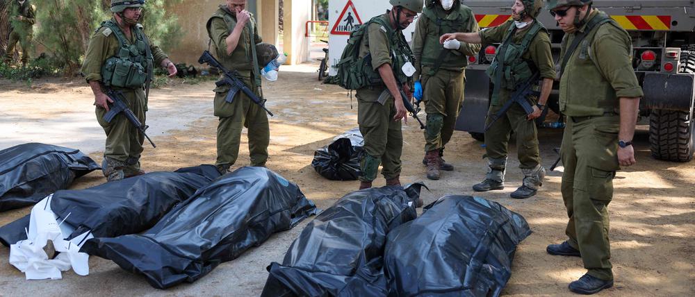 Soldaten bergen die Leichen von getöteten israelischen Zivillisten. 