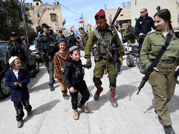 Israeli soldiers protect the Purim parade of Israeli settlers in the old city of Hebron. 