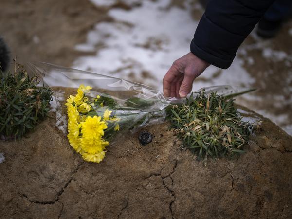 A man lays flowers on a grave in a cemetery during a memorial service marking the anniversary of the start of the war.  The Russian army invaded Ukraine on February 24, 2022.  Photo: Emilio Morenatti/AP/dpa +++ dpa picture radio +++