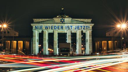 Der Schriftzug «Nie wieder ist jetzt» wird zum 85. Jahrestag der Pogromnacht an das Brandenburger Tor projiziert.