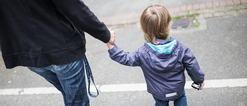 Eine Mutter hält ihren Sohn an der Hand. Mehr als jedes fünfte Kind und jeder vierte junge Erwachsene in Deutschland sind einer Studie zufolge armutsgefährdet.