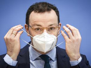 Der damalige Gesundheitsminister Jens Spahn (CDU) nimmt im Januar 2021 zu Beginn einer Pressekonferenz seine Maske ab.