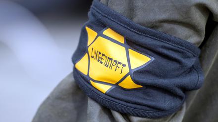 Bei einer Demonstration gegen die Einschränkungen durch die Pandemie-Maßnahmen der Bundesregierung trägt ein Teilnehmer eine Armbinde mit einem gelben Stern, der an einen Judenstern erinnern soll, mit der Aufschrift «Ungeimpft».