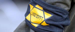 Bei einer Demonstration gegen die Einschränkungen durch die Pandemie-Maßnahmen der Bundesregierung trägt ein Teilnehmer eine Armbinde mit einem gelben Stern, der an einen Judenstern erinnern soll, mit der Aufschrift «Ungeimpft».