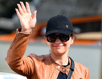 Die französische Schauspielerin Juliette Binoche schützt sich mit Cap und Brille vor der grellen Sonne.