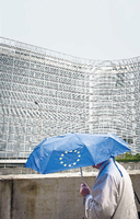 Ein Fußgänger vor dem EU-Kommissionsgebäude im Brüsseler Regen.