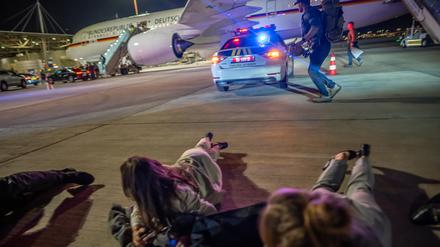 Personen liegen auf dem Flughafen von Tel Aviv vor dem Luftwaffen-Airbus von Bundeskanzler Scholz auf dem Boden. Die Delegation des Bundeskanzlers hatte vor dem Abflug nach Kairo wegen eines Raketenalarms schlagartig das Flugzeug verlassen müssen. 