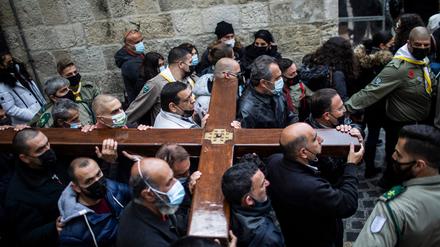 Christliche Gläubige tragen ein Holzkreuz während einer Karfreitagsprozession entlang der Via Dolorosa.