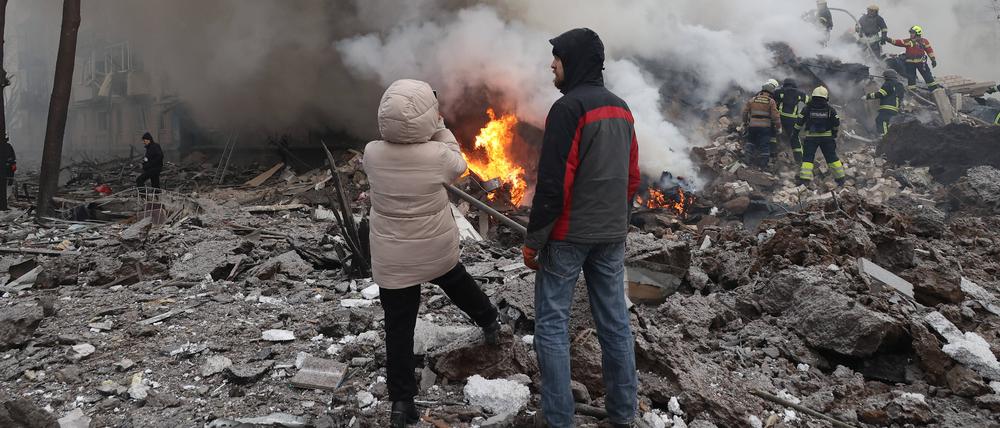 Feuerwehrleute und Zivilisten löschen am 23. Januar 2024 ein Feuer nach dem russischen Raketenangriff auf Charkiw im Nordosten der Ukraine. 