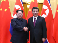 Nordkoreas Machthaber Kim Jong Un und Chinas Präsident Xi Jinping stehen nebeneinander und geben sich die Hand.