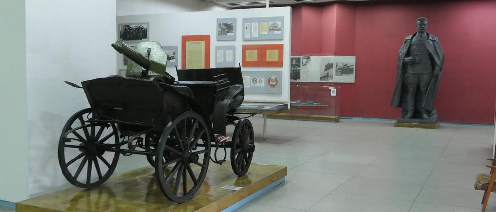 Im Frunse-Museum: Im Vordergrund ein Leiterwagen mit Maschinengewehr aus dem Russischen Bürgerkrieg, hinten eine eine Bronzestatue von Michail Frunse.