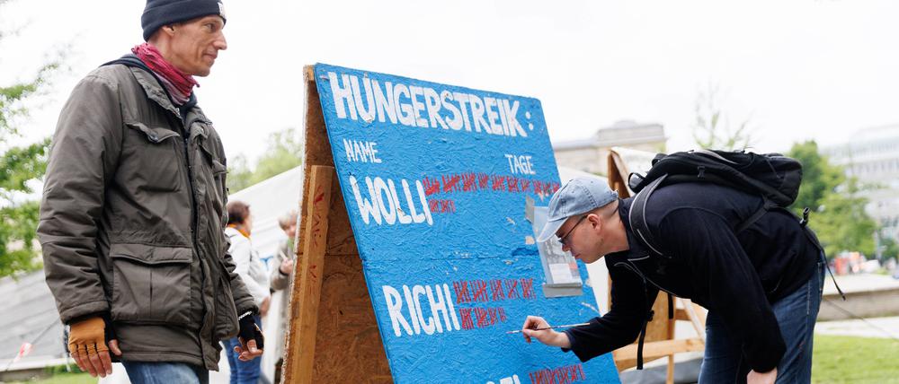 Der Klimaaktivist Wolfgang Metzeler-Kick (l) vom Bündnis «Hungern bis ihr ehrlich seid» malt steht neben der Tafel mit der Anzahl seiner Hungerstreik-Tage neben Adrian Lack (r) nach einer Pressekonferenz über den Gesundheitszustand der Klima-Hungerstreikenden.