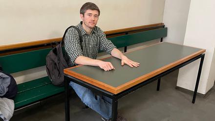 Klimaaktivist Henning Jeschke sitzt festgeklebt an einem Tisch in einem Raum des Amtsgerichts Tiergarten. Im Prozess gegen den Klimaaktivisten ist es zum Eklat gekommen.