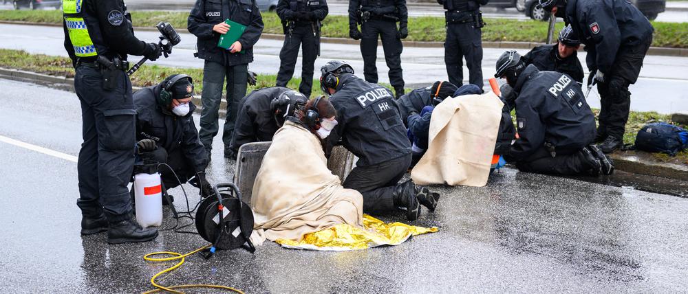 Polizisten arbeiten an den festgeklebten Aktivisten. Klimaaktivisten der Bewegung »Letzte Generation« haben am Samstag die Elbbrücken stadteinwärts blockiert.