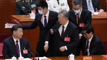 Hu Jintao (M), ehemaliger Präsident von China, wird aus der Abschlusszeremonie des 20. Nationalen Kongresses der Kommunistischen Partei Chinas in der Großen Halle des Volkes hinausbegleitet.