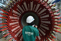 Einen Generatorständer betrachtet eine Mitarbeiterin der Factory Services im Siemens-Generatorenwerk.