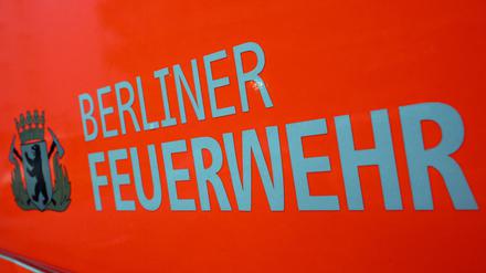 Der Schriftzug ·Berliner Feuerwehr· und das Wappen Berliner Feuerwehr mit dem Berliner Bären stehen auf der Tür eines Feuerwehrfahrzeuges. (Symbolbild)