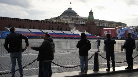 Menschen schauen auf den leeren Roten Platz, der für die Vorbereitung der Siegesparade neben dem Moskauer Kreml gesperrt ist.