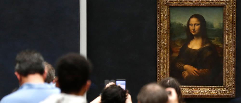 Besucher machen Fotos vor Leonardo da Vincis Meisterwerk „Mona Lisa“ im Louvre-Museum. 