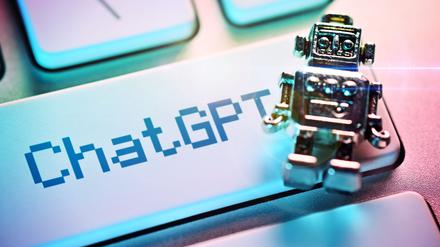 Miniatur-Roboter auf einer Computertaste mit der Aufschrift ChatGPT.
