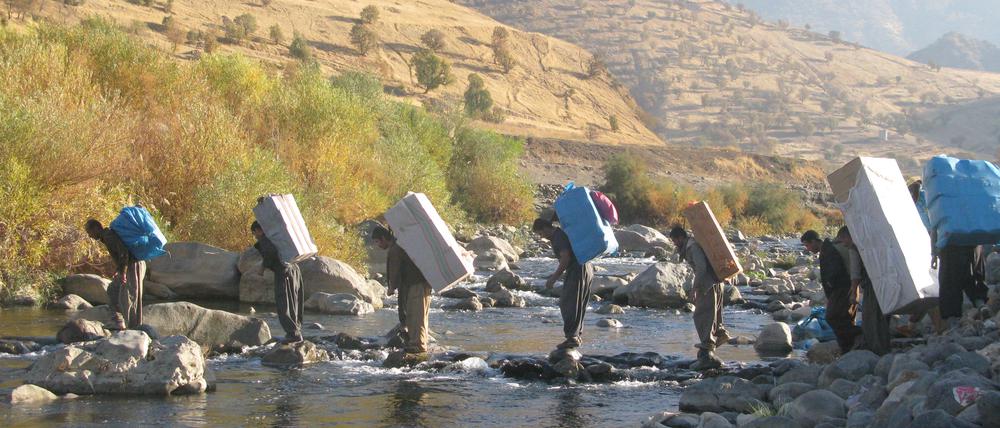 Schwere Last. Kurdische Lastenträger überqueren die Grenze durch einen Fluss in Richtung iranische Grenze. (Foto von Rahman Hassani/SOPA Images/LightRo)