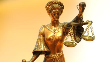 Eine goldfarbene Justitia-Figur steht in einem Gericht. (Symbolfoto)