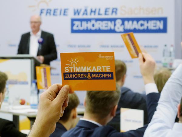 Stimmkarten werden beim Landesparteitag der Freien Wähler Sachsen in die Höhe gehalten. 