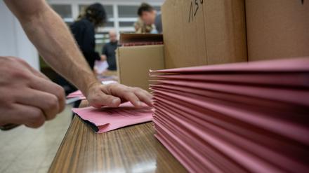 Wahlhelfer bei der bayerischen Landtagswahl öffnen die ersten Briefwahlumschläge.