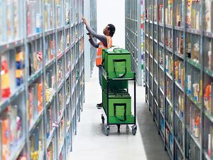 Ein Mitarbeiter eines Lebensmittellieferdienstes packt im Depot der Firma in Berlin die bestellten Waren in eine Transporttasche.
